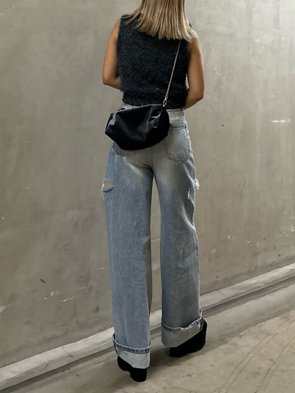 ブルー系のデニムパンツ、グレー系のタンクトップ、グレー系のハンドバッグを着用したレディースの夏コーディネートの3枚目の写真