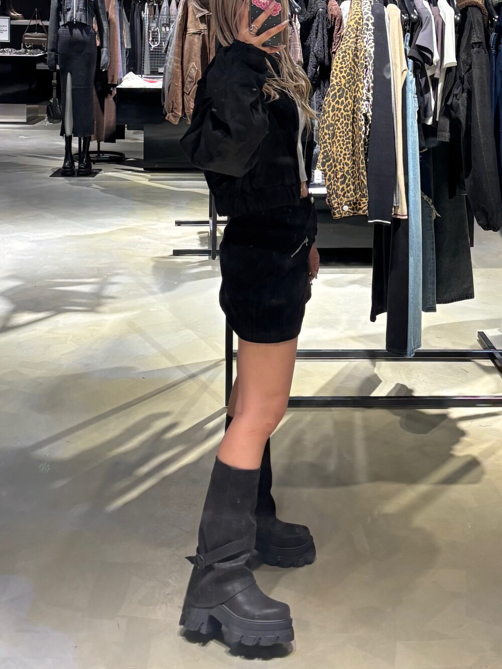 ブラック系のブルゾン、グレー系のTシャツ/カットソー、ブラック系のスカートを着用したレディースの秋コーディネートの2枚目の写真