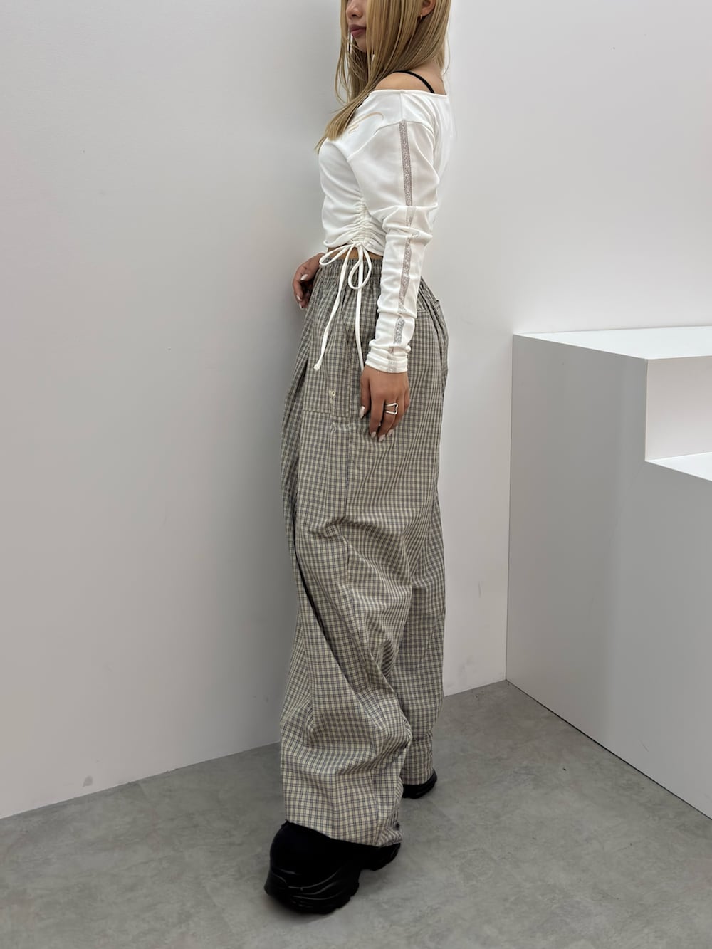 ホワイト系のTシャツ/カットソー、ベージュ系のその他パンツ、ブラック系のスニーカーを着用したレディースの春コーディネートの2枚目の写真