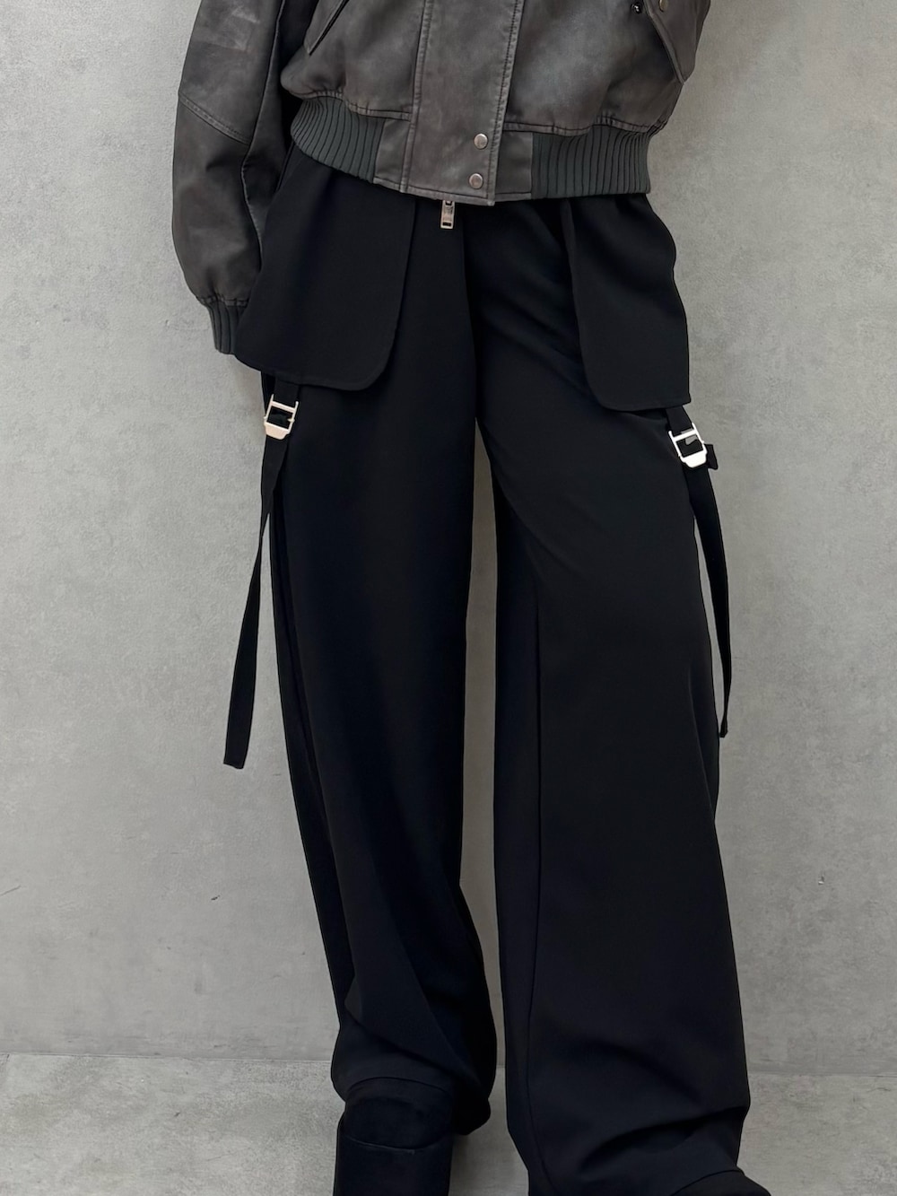 グレー系のブルゾン、ブラック系のその他パンツ、ブラック系のブーツを着用したレディースの秋コーディネートの5枚目の写真