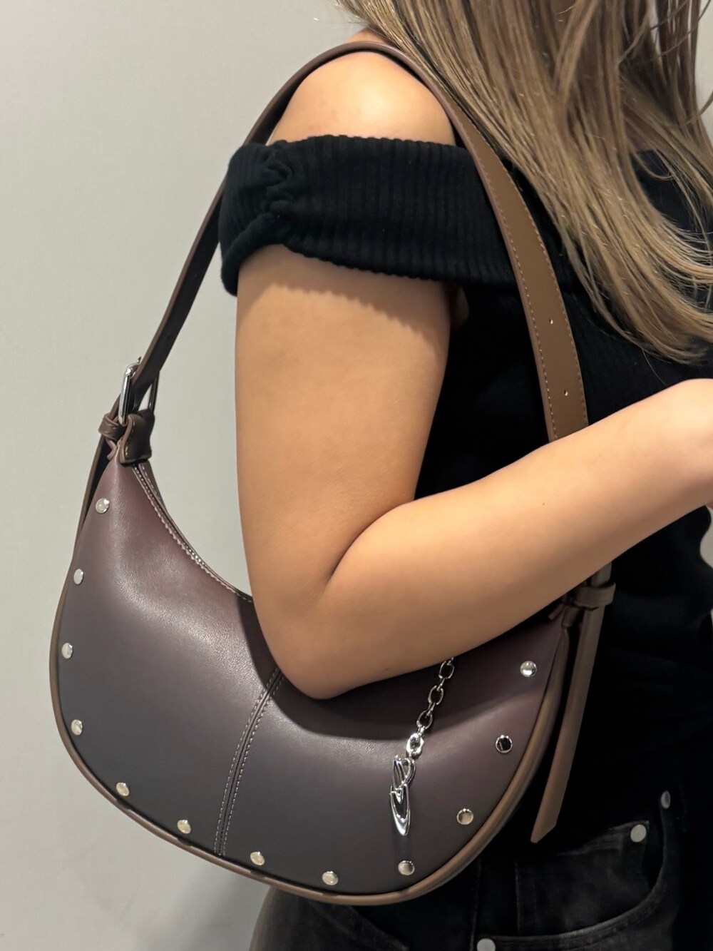 ブラック系のニット/セーター、ブラック系のデニムパンツ、ブラウン系のサンダルを着用したレディースの春コーディネートの7枚目の写真