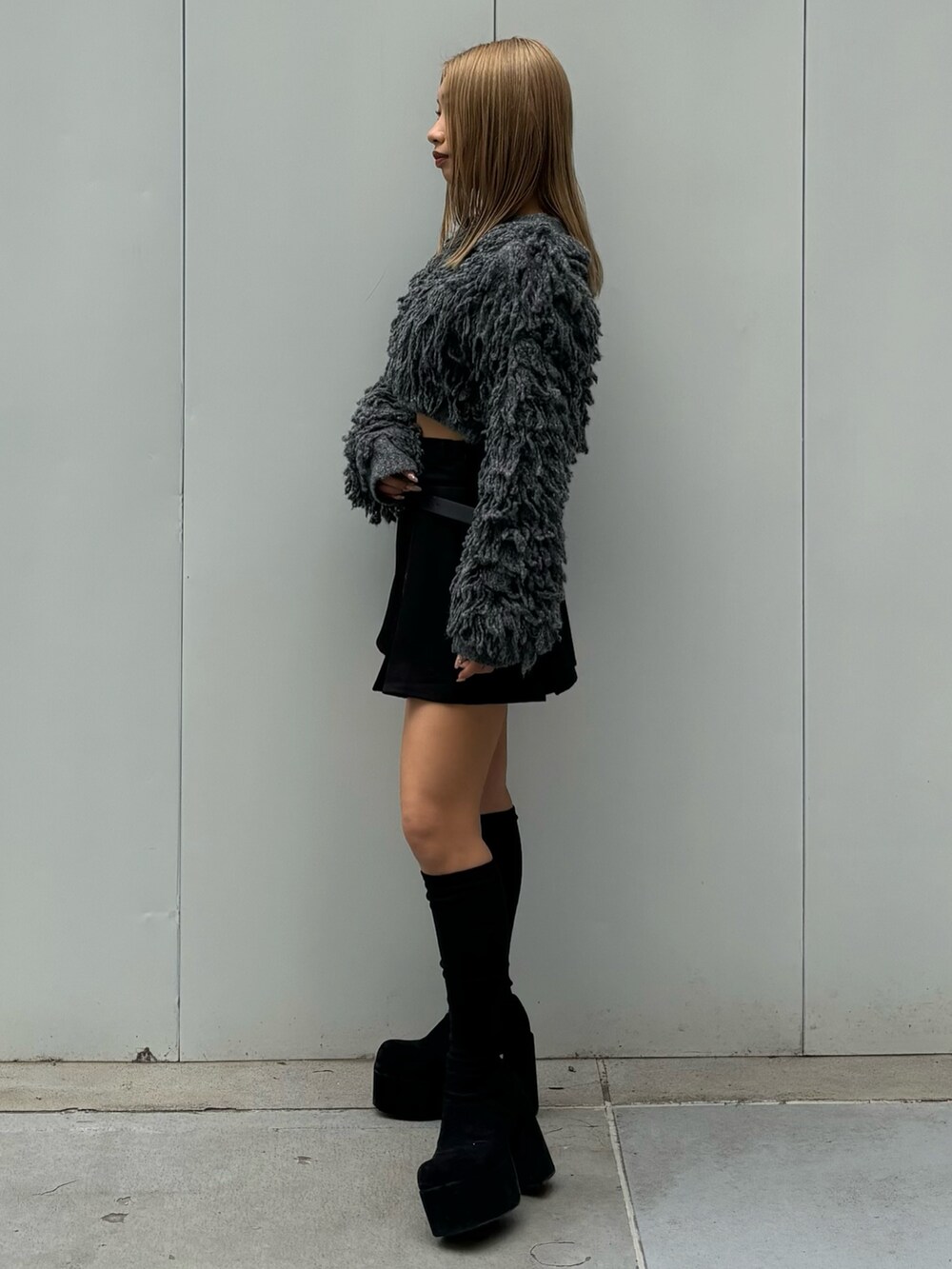 ブラック系のスカート、グレー系のニット/セーター、その他のブーツを着用したレディースの秋コーディネートの2枚目の写真