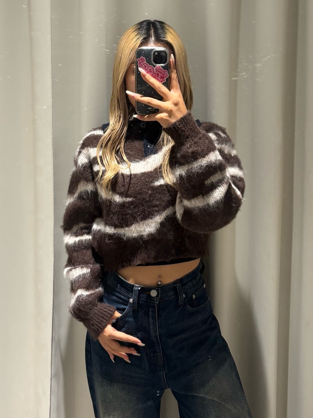 ブラウン系のニット/セーター、ブルー系のデニムパンツ、ブラック系のブーツを着用したレディースの秋コーディネートの4枚目の写真