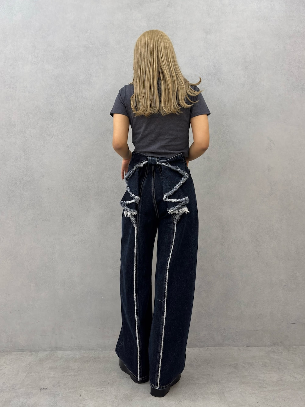 グレー系のTシャツ/カットソー、ブルー系のデニムパンツ、ブラック系のサンダルを着用したレディースの春コーディネートの3枚目の写真