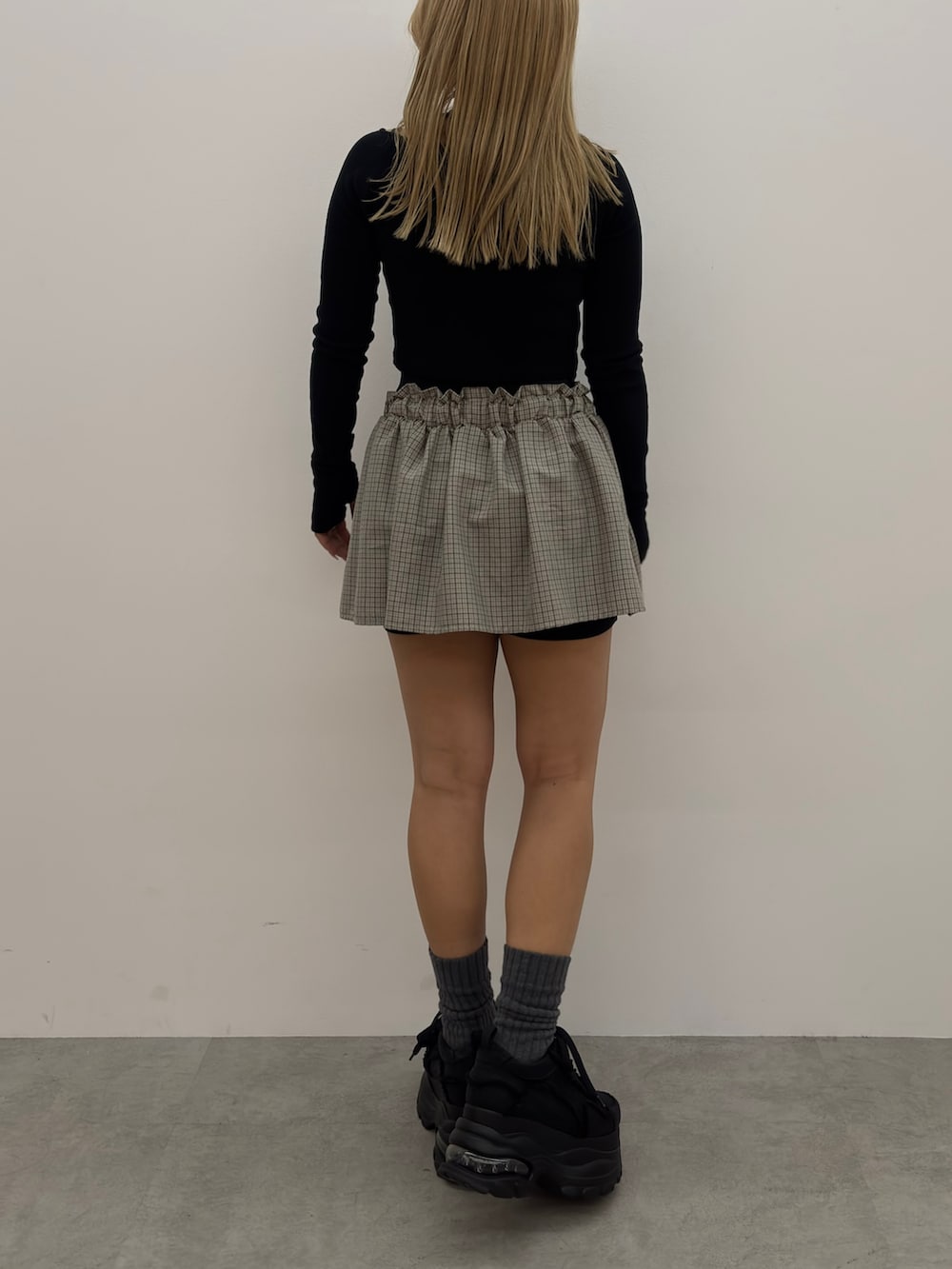 ブラック系のシャツ/ブラウス、ブラック系のスカート、ブラック系のスニーカーを着用したレディースの冬コーディネートの3枚目の写真