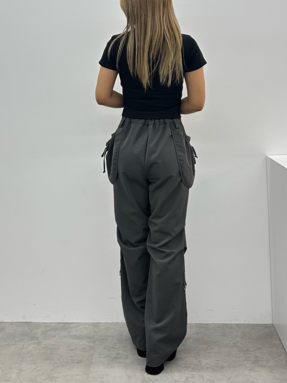 ブラック系のTシャツ/カットソー、グレー系のその他パンツ、ブラック系のサンダルを着用したレディースの夏コーディネートの3枚目の写真