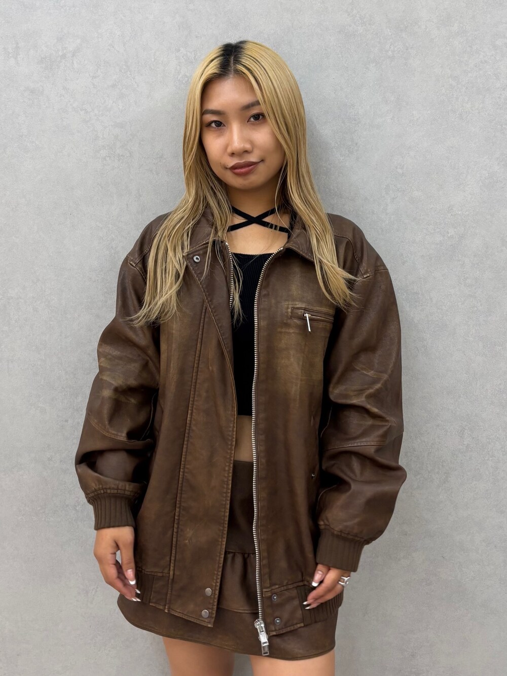 ブラック系のニット/セーター、ブラウン系のブルゾン、ブラック系のブーツを着用したレディースの秋コーディネートの4枚目の写真