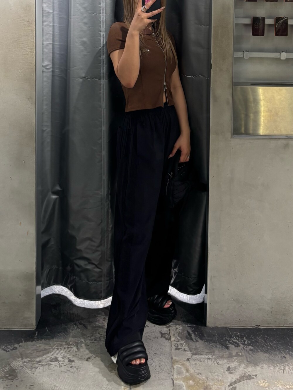 ブラウン系のTシャツ/カットソー、ブラック系のその他パンツ、ブラック系のハンドバッグを着用したレディースの夏コーディネートの2枚目の写真