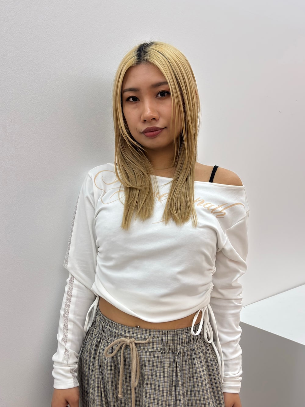 ホワイト系のTシャツ/カットソー、ベージュ系のその他パンツ、ブラック系のスニーカーを着用したレディースの春コーディネートの4枚目の写真