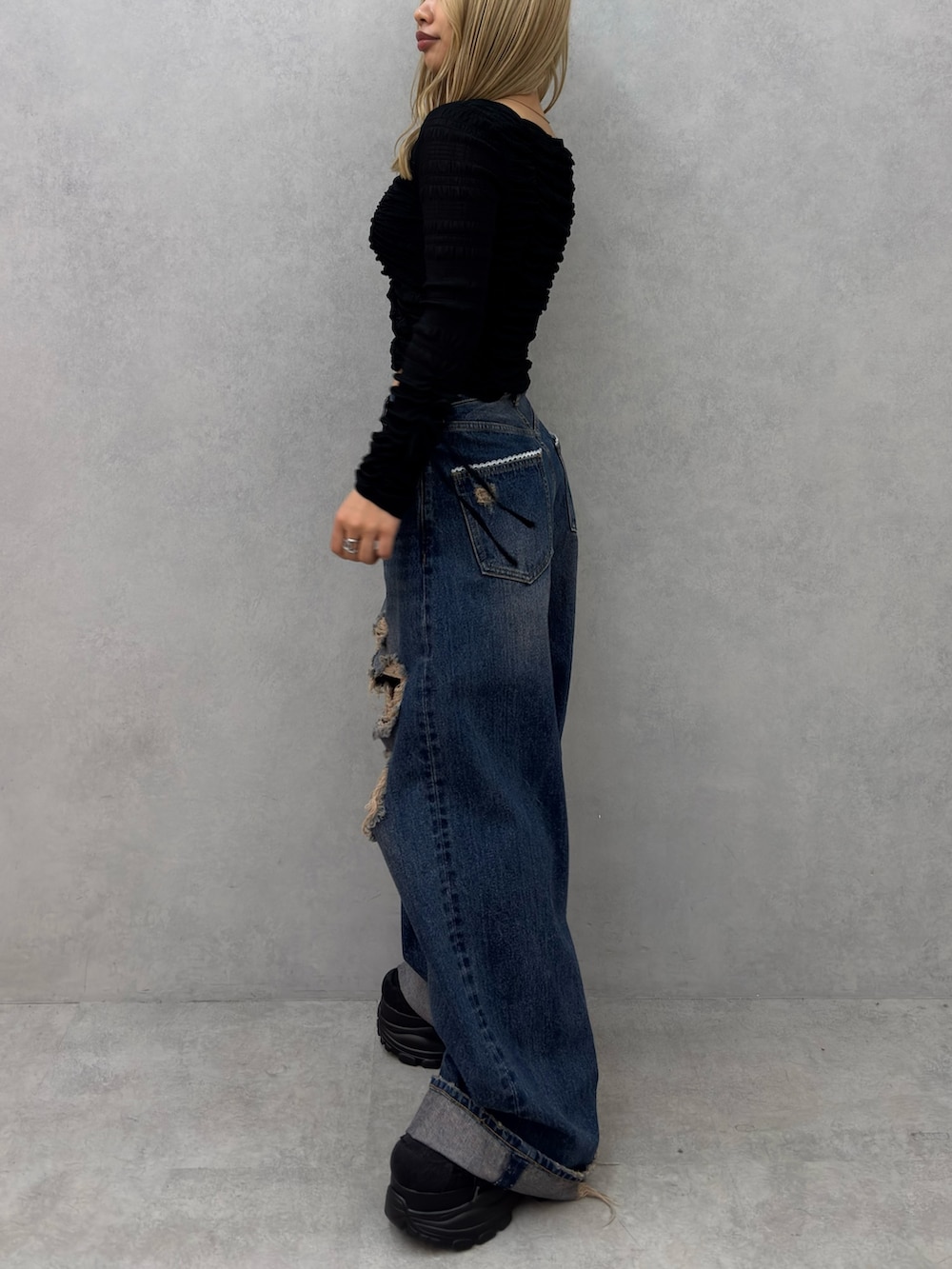 ブラック系のTシャツ/カットソー、ブルー系のデニムパンツ、ブラック系のスニーカーを着用したレディースの冬コーディネートの2枚目の写真