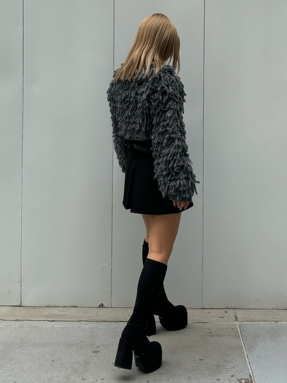 ブラック系のスカート、グレー系のニット/セーター、その他のブーツを着用したレディースの秋コーディネートの3枚目の写真