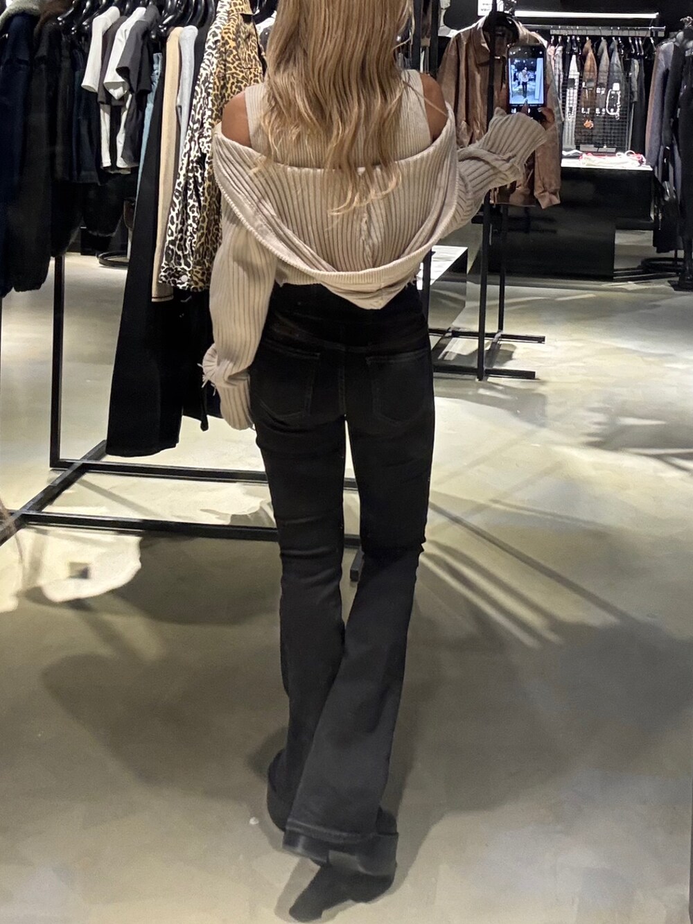 ホワイト系のニット/セーター、ブラック系のデニムパンツ、ブラック系のブーツを着用したレディースの秋コーディネートの3枚目の写真