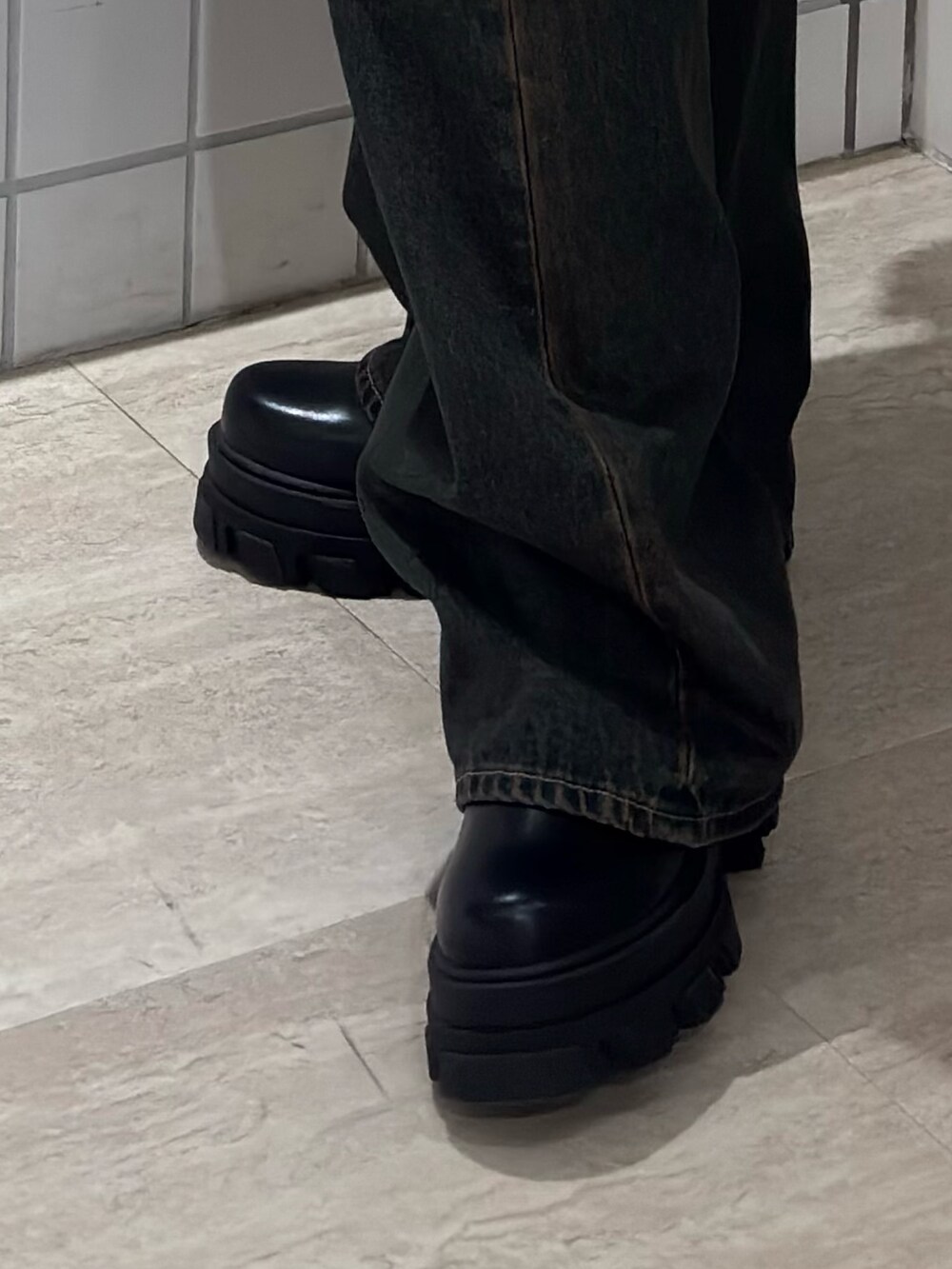 ブラック系のTシャツ/カットソー、ブルー系のデニムパンツ、ブラック系のブーツを着用したレディースの春コーディネートの7枚目の写真