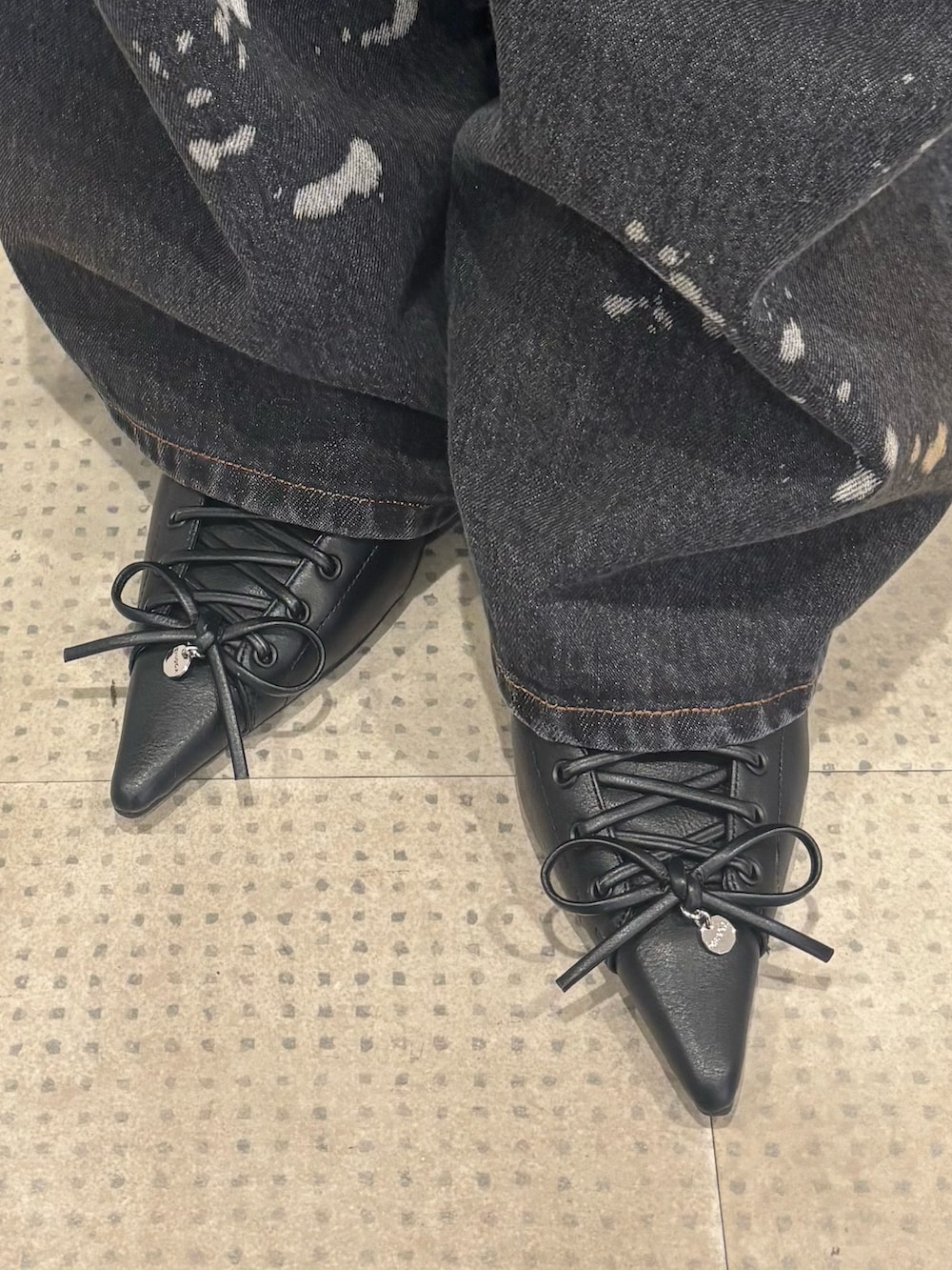 ブラック系のパンプス、ブラック系のデニムパンツ、グレー系のニット/セーターを着用したレディースの春コーディネートの7枚目の写真