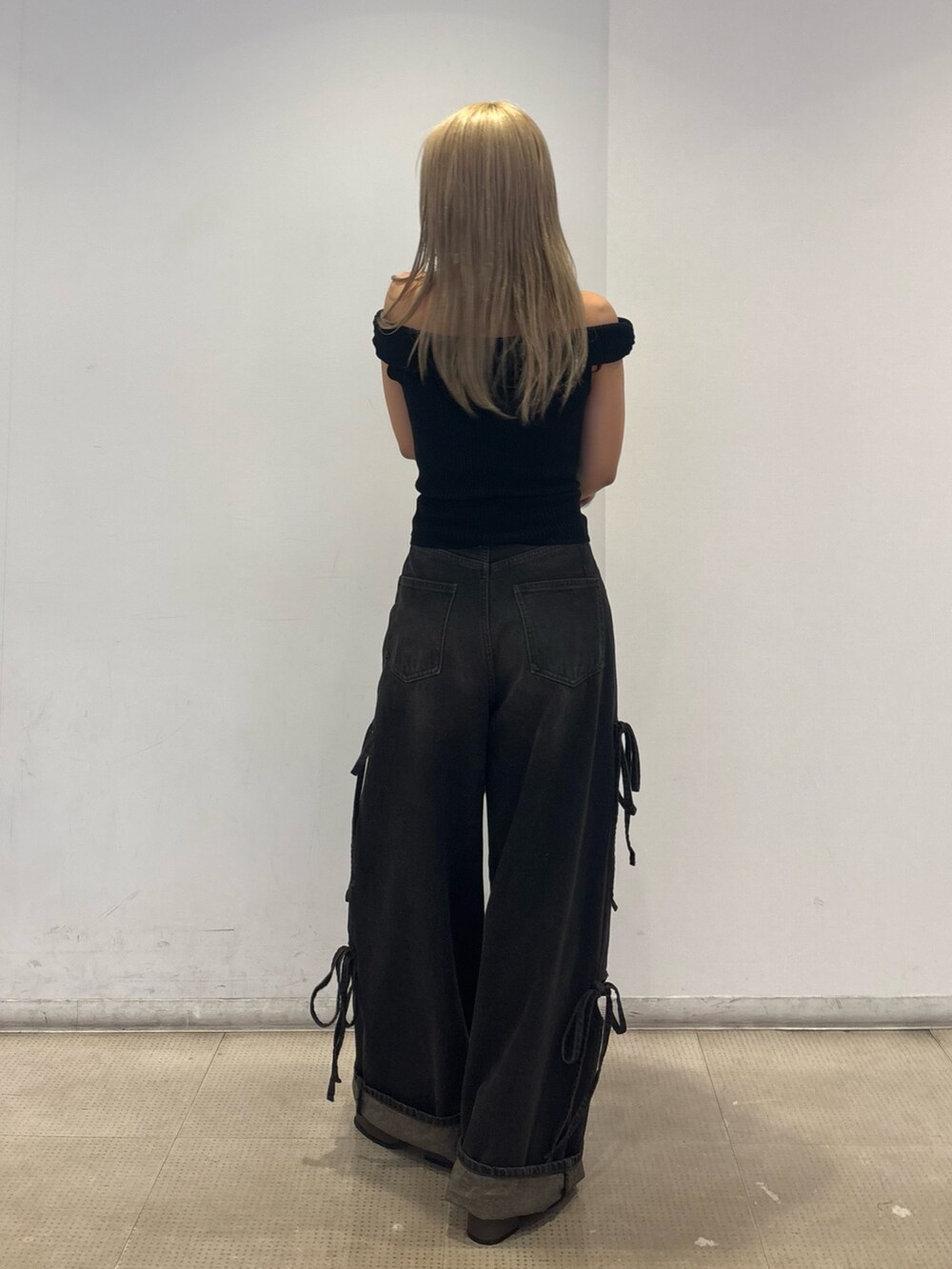 ブラック系のニット/セーター、ブラック系のデニムパンツ、ブラウン系のサンダルを着用したレディースの春コーディネートの3枚目の写真