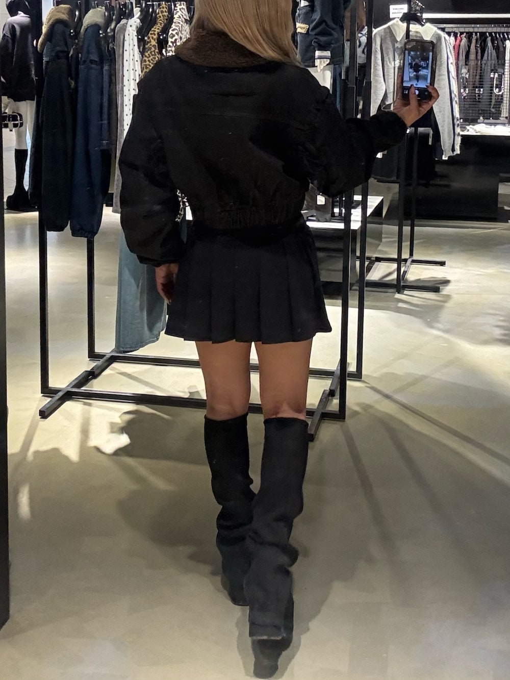 ブラック系のブルゾン、ブラック系のスカート、ブラック系のブーツを着用したレディースの秋コーディネートの3枚目の写真