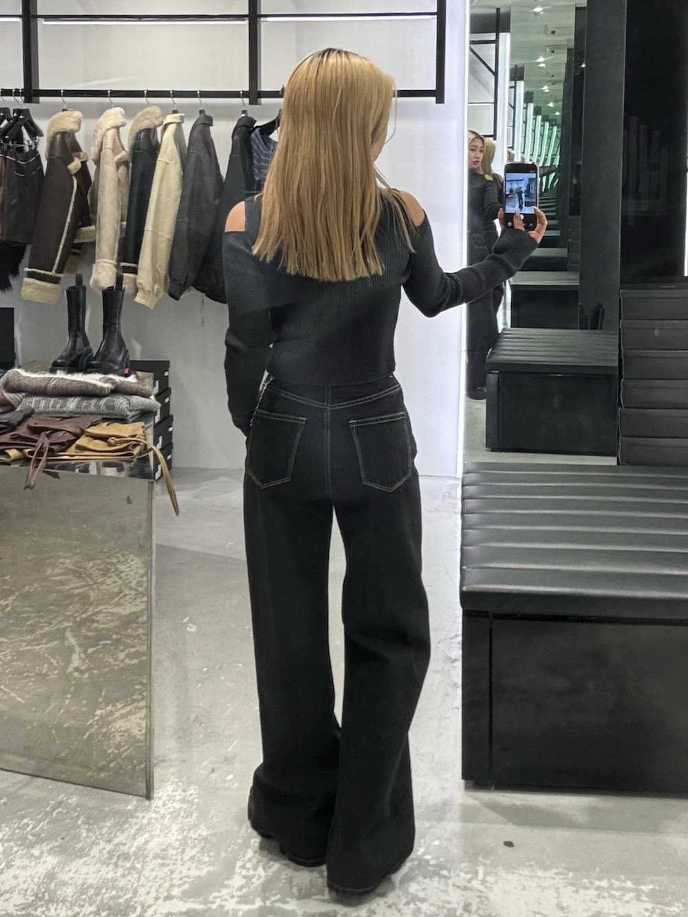 ブラック系のニット/セーター、ブルー系のデニムパンツ、ブラック系のブーツを着用したレディースの冬コーディネートの3枚目の写真