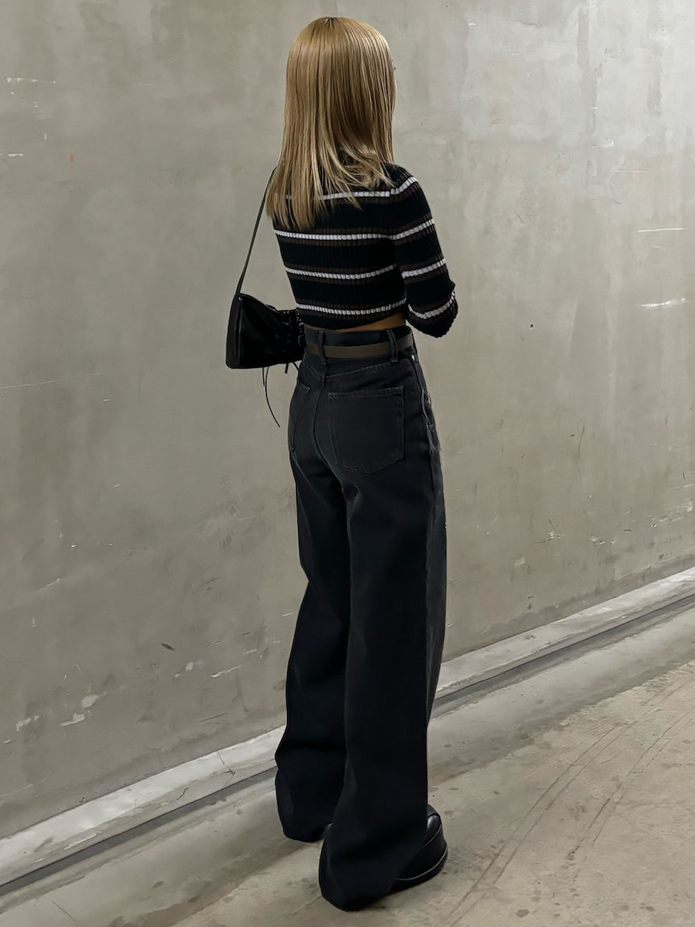 ブラック系のデニムパンツ、その他のニット/セーター、ブラック系のショルダーバッグを着用したレディースの秋コーディネートの3枚目の写真