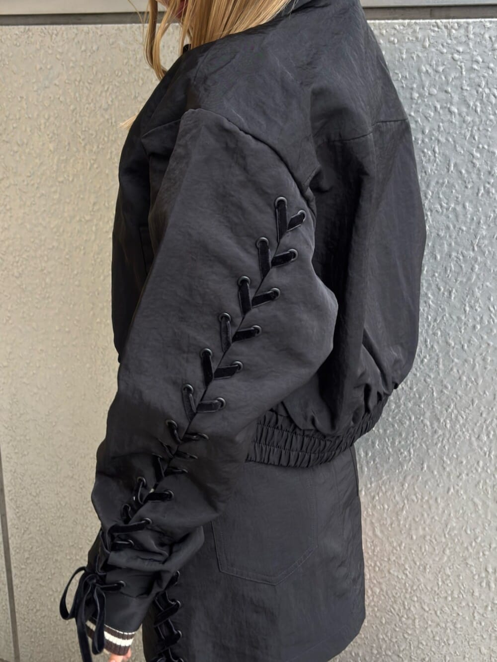 ブラック系のブーツ、ブラック系のスカート、ブラック系のブルゾンを着用したレディースの冬コーディネートの5枚目の写真