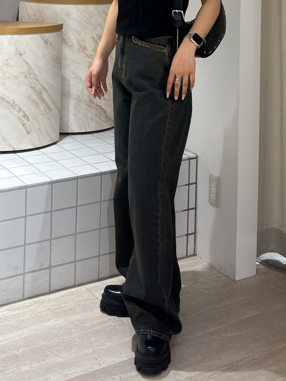 ブラック系のTシャツ/カットソー、ブルー系のデニムパンツ、ブラック系のブーツを着用したレディースの春コーディネートの5枚目の写真