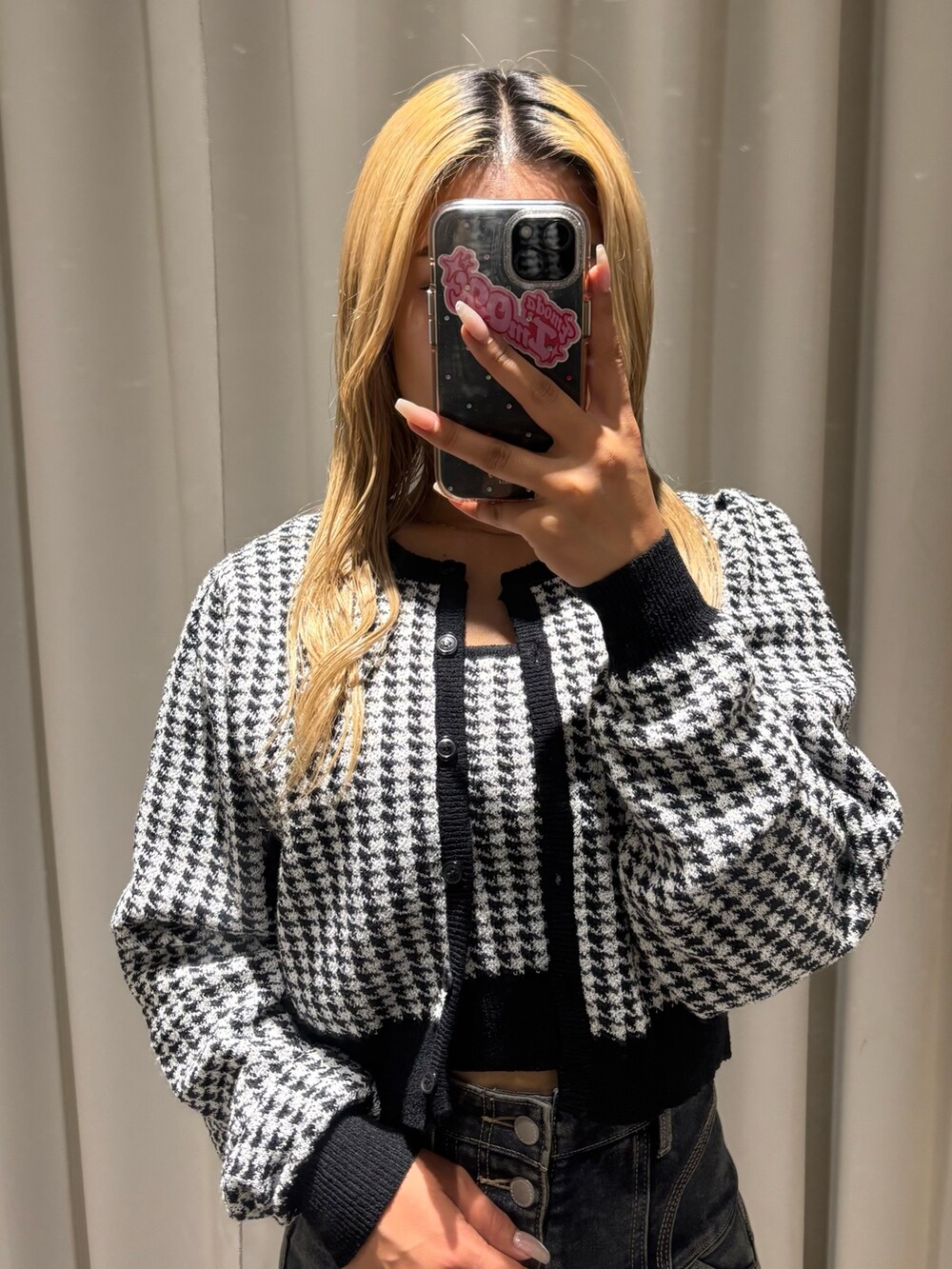 ブラック系のニット/セーター、ブルー系のデニムパンツ、ブラック系のブーツを着用したレディースの秋コーディネートの4枚目の写真