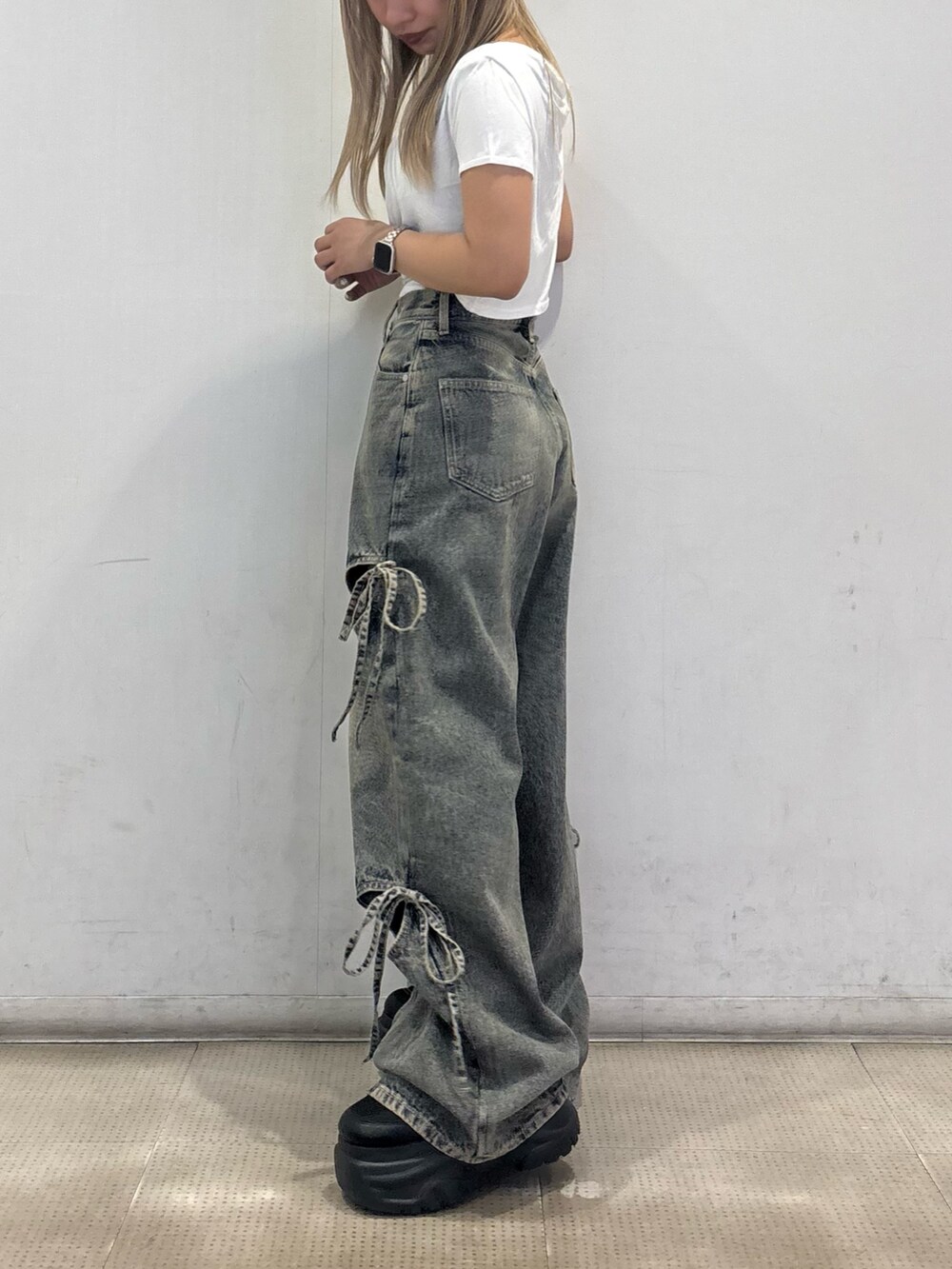 ホワイト系のTシャツ/カットソー、ブルー系のデニムパンツ、ブラック系のスニーカーを着用したレディースの夏コーディネートの2枚目の写真