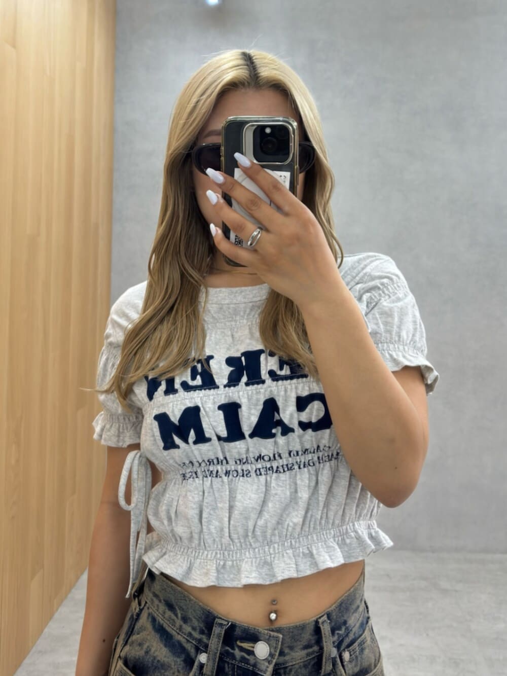 ブルー系のデニムパンツ、ホワイト系のサンダル、グレー系のTシャツ/カットソーを着用したレディースの春コーディネートの4枚目の写真