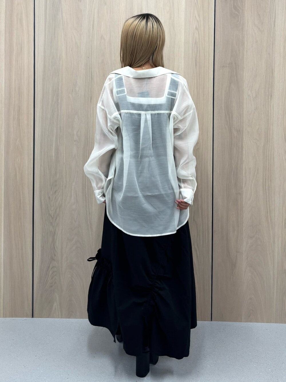 ブラック系のワンピース、ホワイト系のシャツ/ブラウス、ブラック系のサンダルを着用したレディースの春コーディネートの3枚目の写真