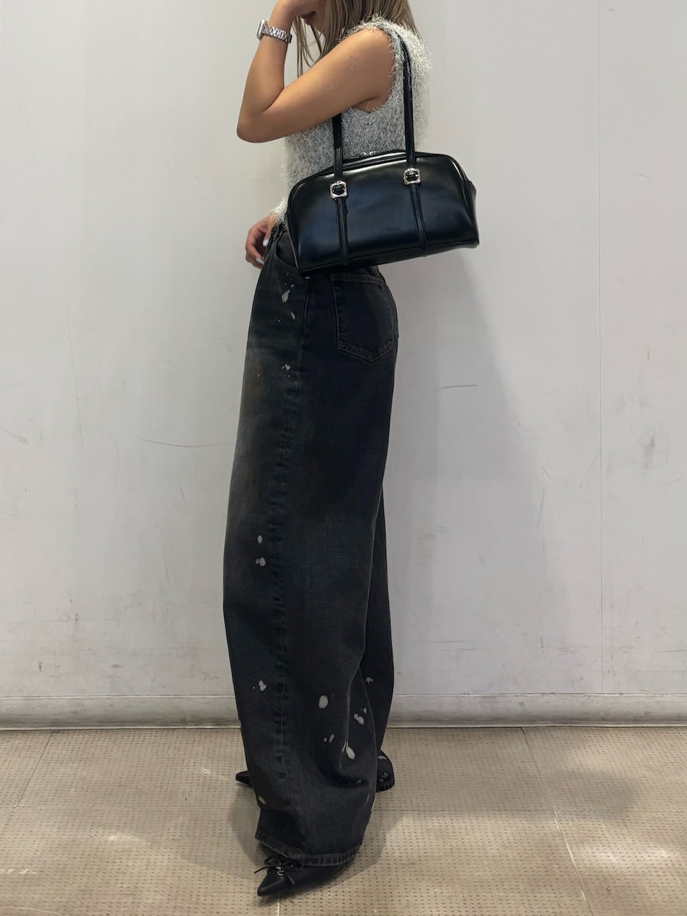 ブラック系のパンプス、ブラック系のデニムパンツ、グレー系のニット/セーターを着用したレディースの春コーディネートの2枚目の写真