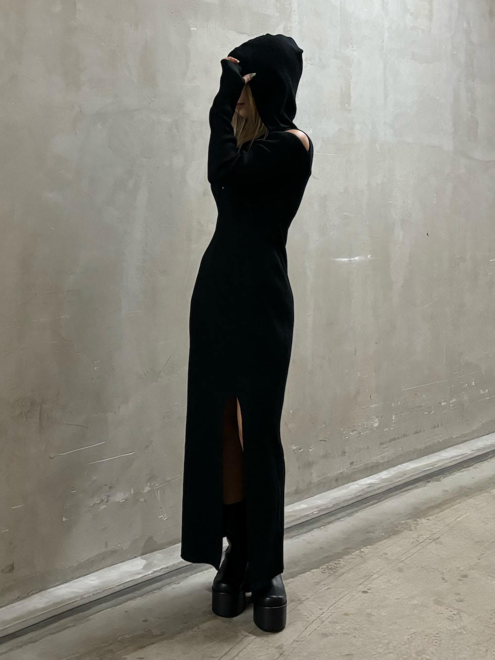 ブラック系のワンピース、ブラック系のブーツを着用したレディースの秋コーディネートの2枚目の写真