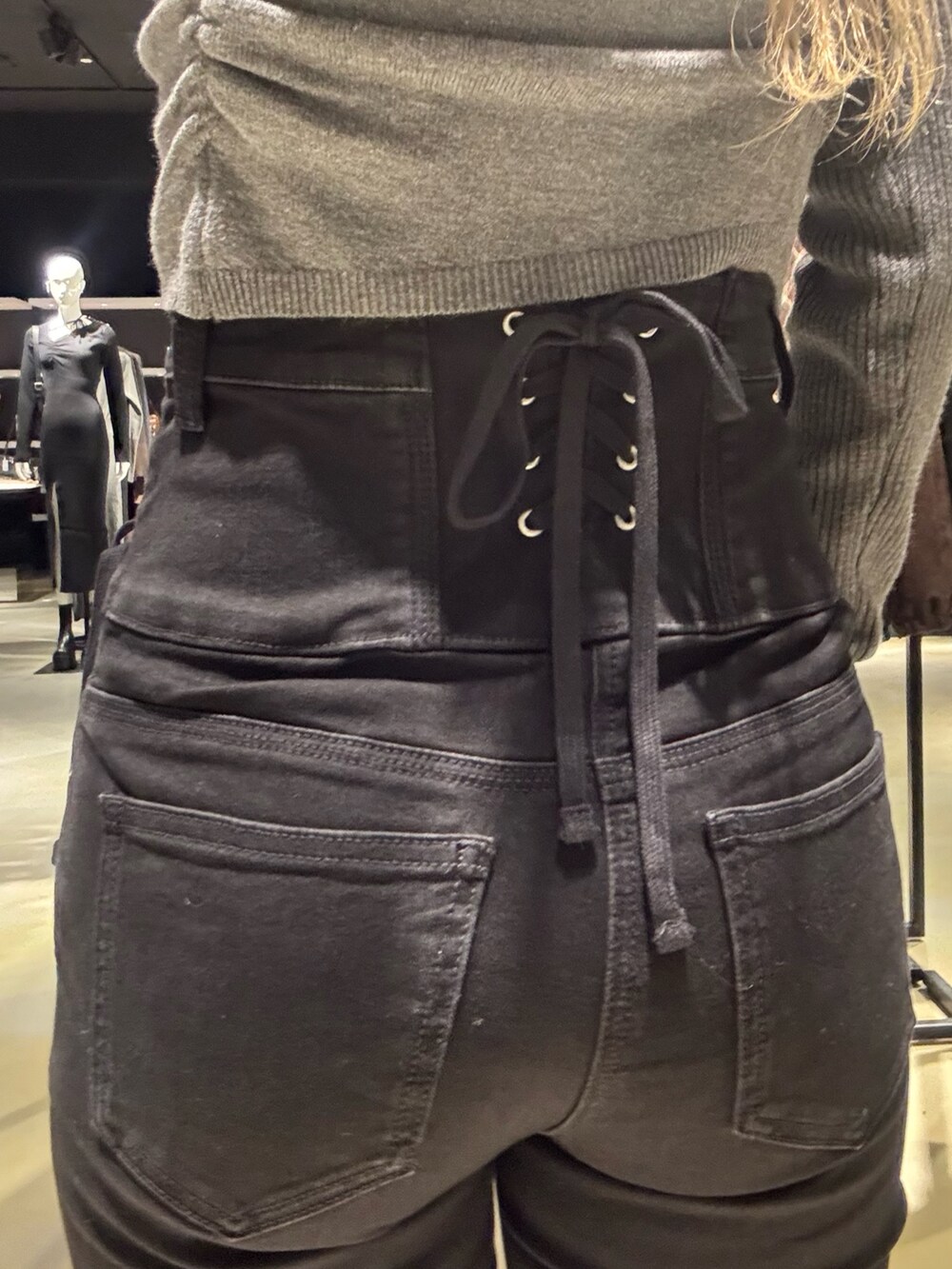 ブラック系のデニムパンツ、ブラック系のブーツ、グレー系のニット/セーターを着用したレディースの冬コーディネートの5枚目の写真