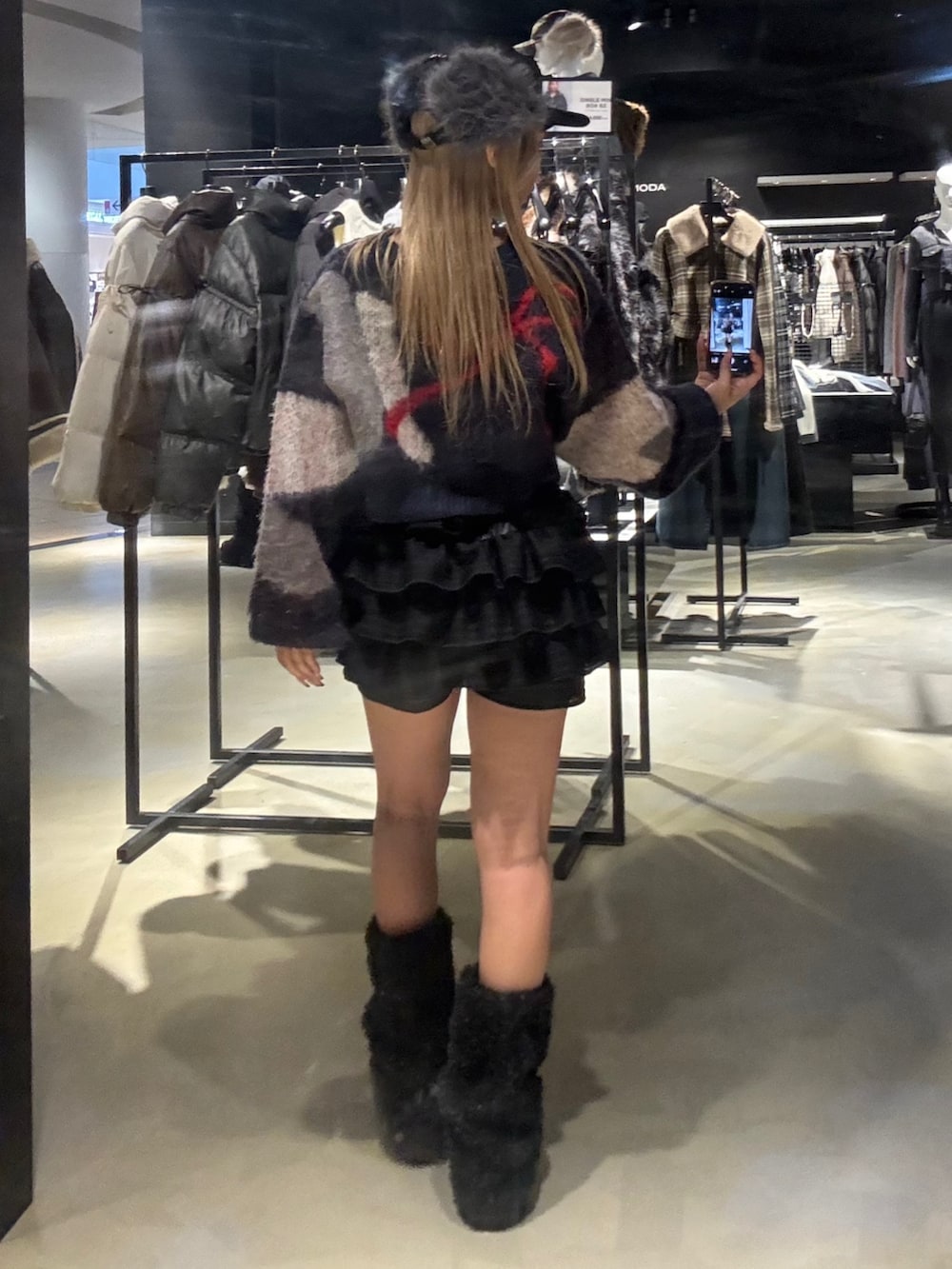 ブルー系のニット/セーター、ブラック系のその他パンツ、ブラック系のブーツを着用したレディースの冬コーディネートの3枚目の写真