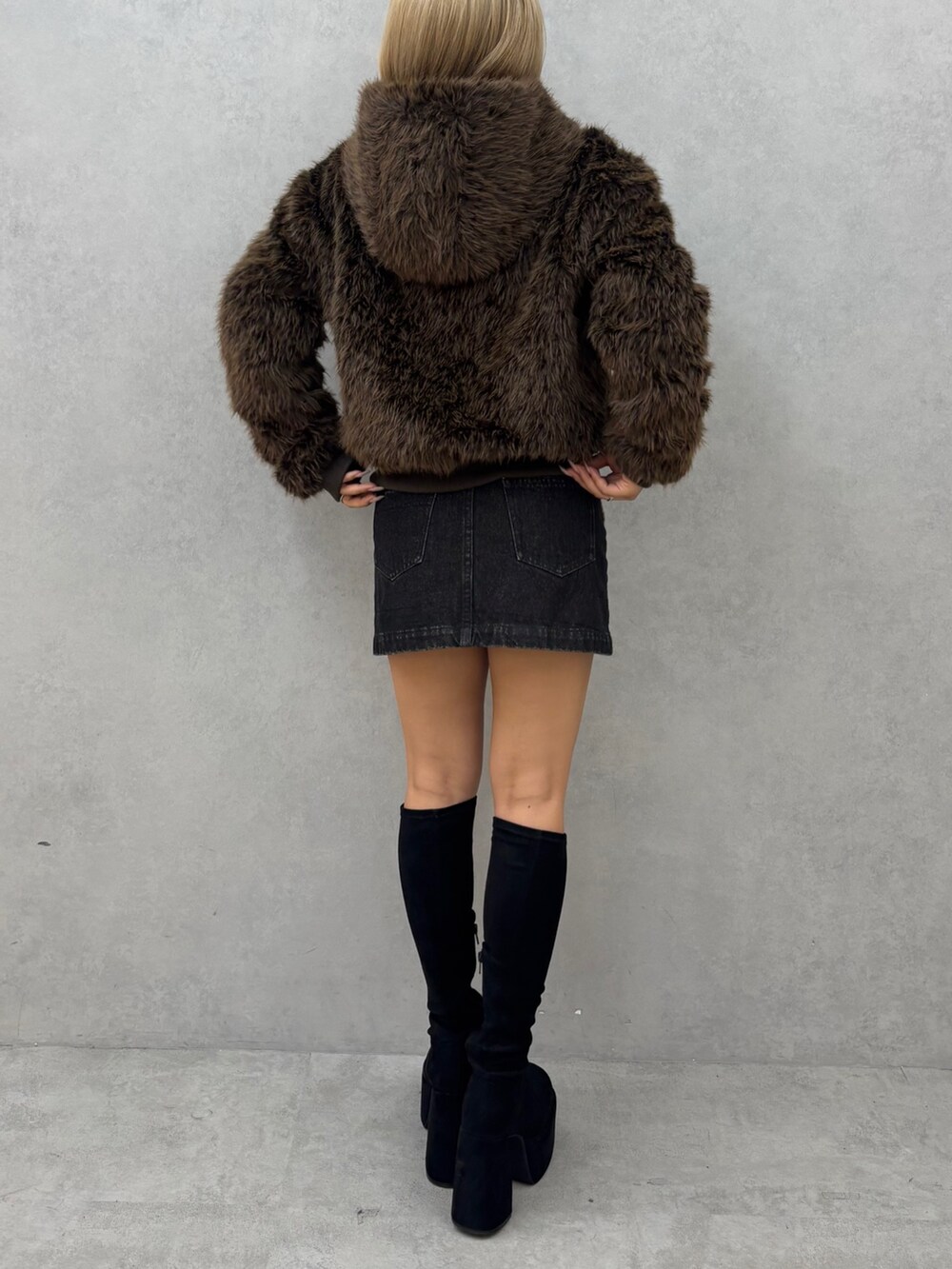 ブラウン系のブルゾン、ブラック系のスカート、ブラック系のブーツを着用したレディースの秋コーディネートの3枚目の写真