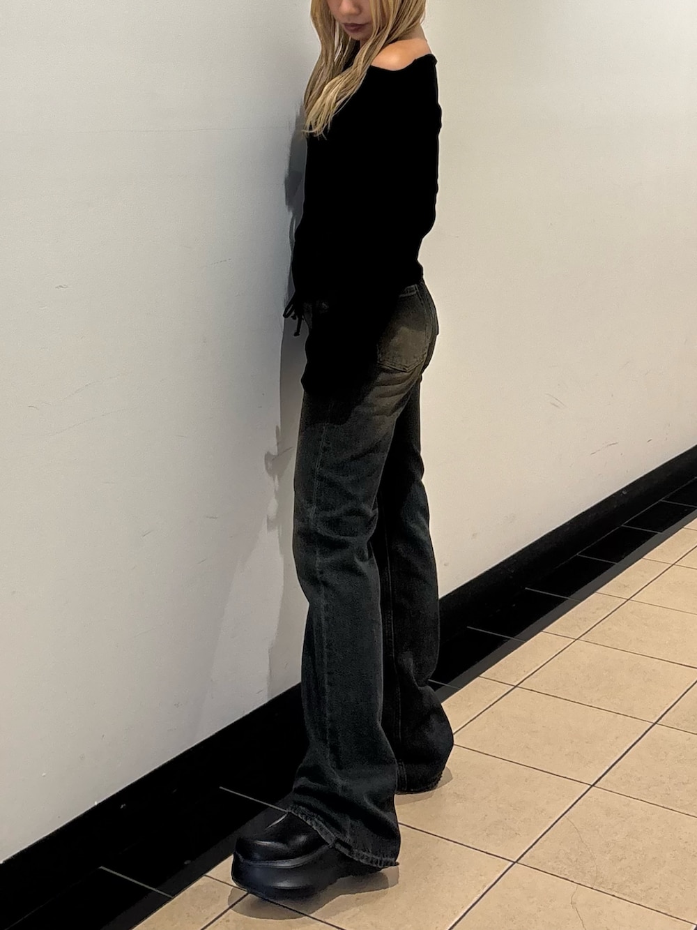 ブルー系のデニムパンツ、ブラック系のスリッポン、ブラック系のTシャツ/カットソーを着用したレディースの秋コーディネートの2枚目の写真