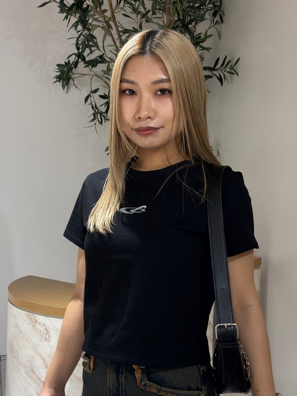 ブラック系のTシャツ/カットソー、ブルー系のデニムパンツ、ブラック系のブーツを着用したレディースの春コーディネートの4枚目の写真