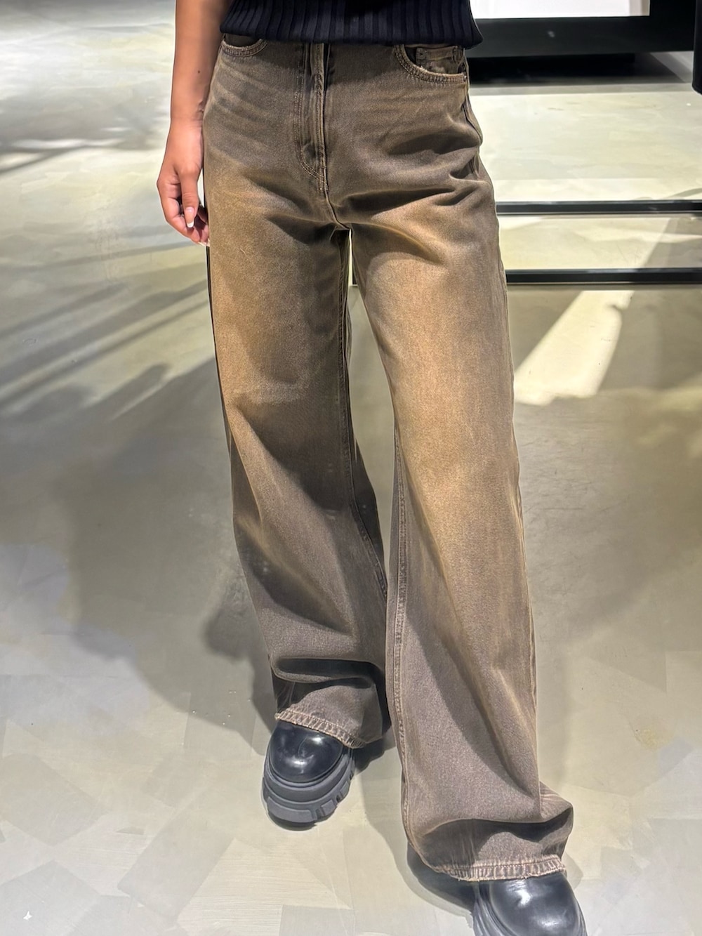 ブラック系のニット/セーター、ブラウン系のデニムパンツ、ブラック系のブーツを着用したレディースの秋コーディネートの5枚目の写真