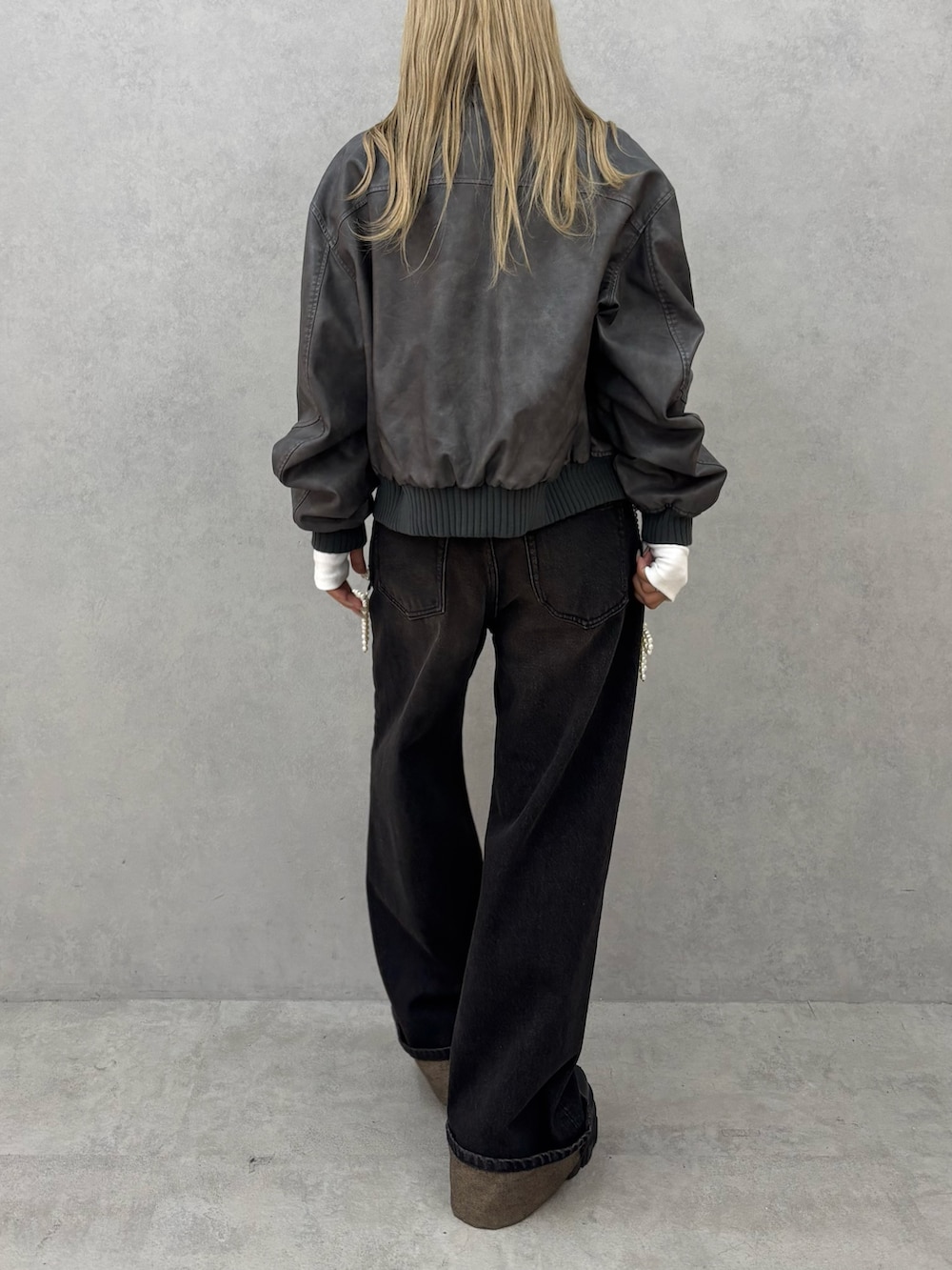 ホワイト系のTシャツ/カットソー、グレー系のブルゾン、ブラック系のデニムパンツを着用したレディースの秋コーディネートの3枚目の写真