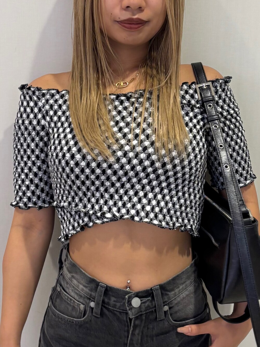 ブラック系のスニーカー、グレー系のTシャツ/カットソー、ブラック系のハンドバッグを着用したレディースの夏コーディネートの4枚目の写真