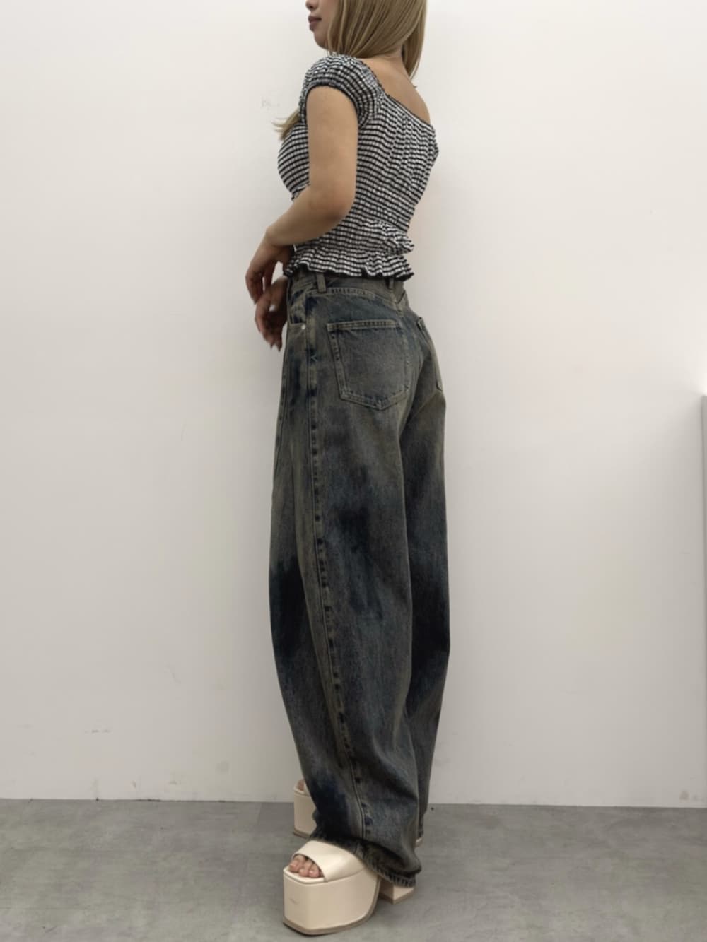 ブルー系のデニムパンツ、ホワイト系のサンダル、その他のTシャツ/カットソーを着用したレディースの春コーディネートの2枚目の写真
