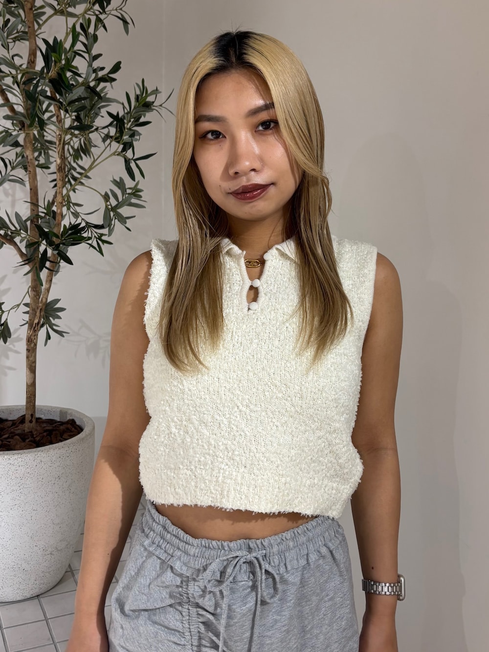 ホワイト系のニット/セーター、グレー系のスカート、ブラック系のサンダルを着用したレディースの夏コーディネートの4枚目の写真