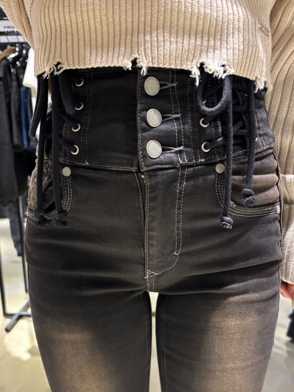 ホワイト系のニット/セーター、ブラック系のデニムパンツ、ブラック系のブーツを着用したレディースの秋コーディネートの5枚目の写真