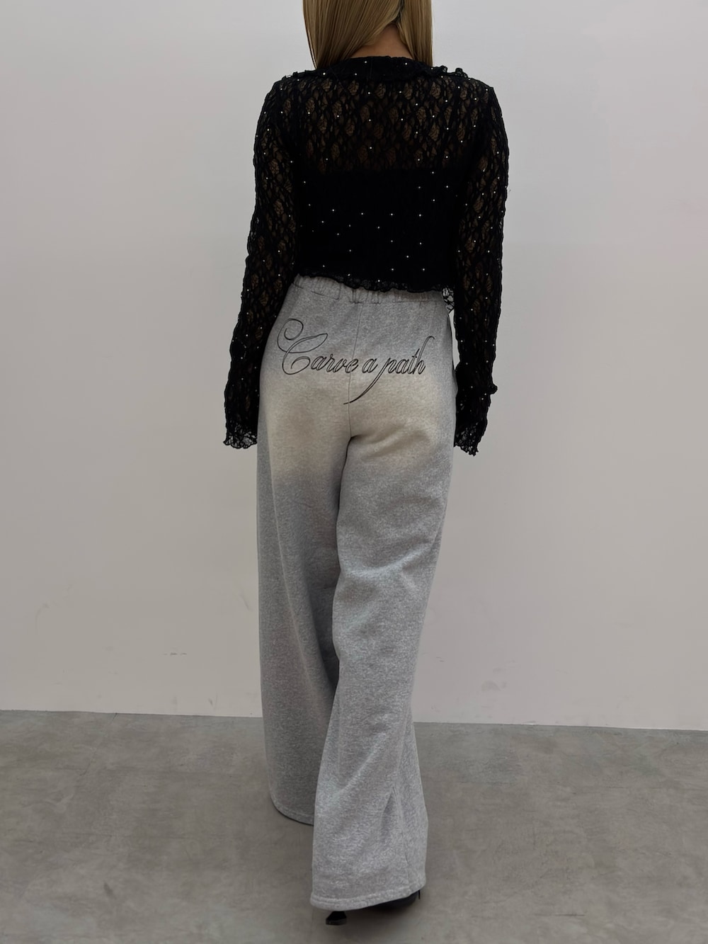 ブラック系のTシャツ/カットソー、グレー系のスウェットパンツ、ブラック系のスニーカーを着用したレディースの春コーディネートの3枚目の写真