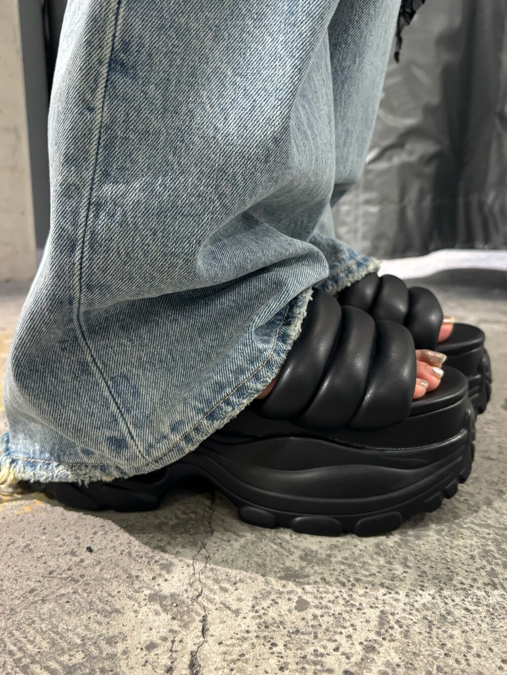 ブラック系のTシャツ/カットソー、ブルー系のデニムパンツ、ブラック系のサンダルを着用したレディースの夏コーディネートの7枚目の写真