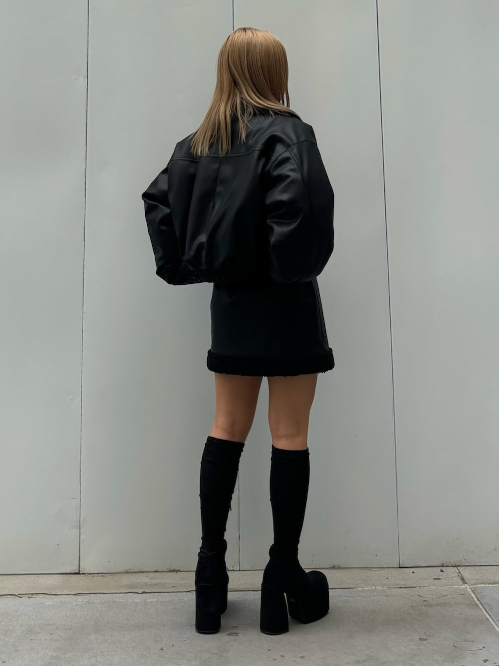 ブラック系のブルゾン、ブラック系のスカート、その他のブーツを着用したレディースの秋コーディネートの3枚目の写真