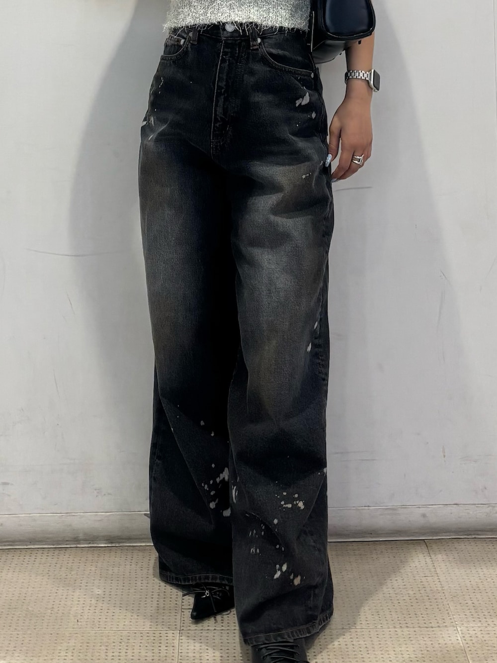 ブラック系のパンプス、ブラック系のデニムパンツ、グレー系のニット/セーターを着用したレディースの春コーディネートの5枚目の写真