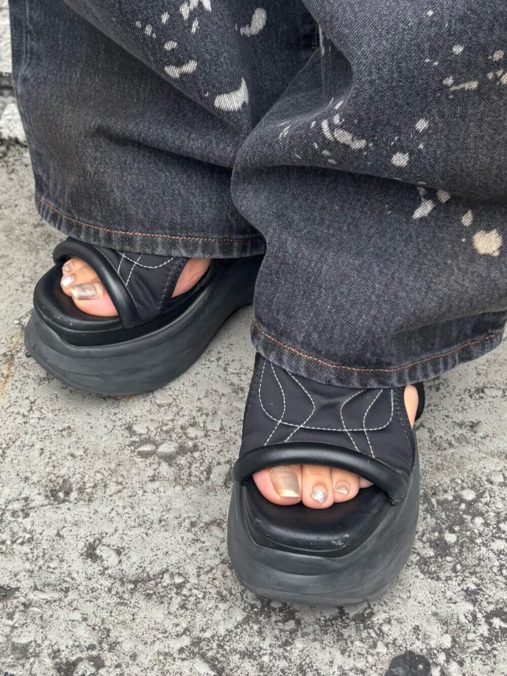 ブラック系のサンダル、ブラック系のTシャツ/カットソー、ブラック系のデニムパンツを着用したレディースの春コーディネートの7枚目の写真