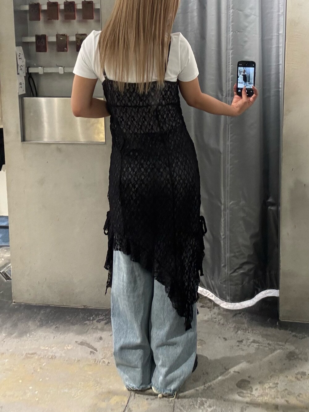 ブラック系のワンピース、ホワイト系のTシャツ/カットソー、ブルー系のデニムパンツを着用したレディースの夏コーディネートの3枚目の写真