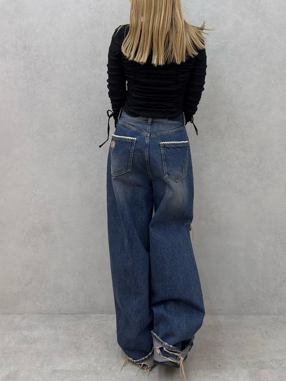 ブラック系のTシャツ/カットソー、ブルー系のデニムパンツ、ブラック系のスニーカーを着用したレディースの冬コーディネートの3枚目の写真