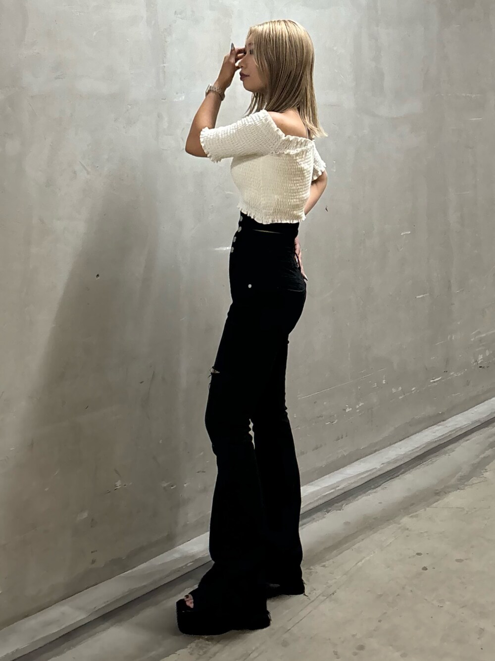 ブラック系のデニムパンツ、ホワイト系のTシャツ/カットソー、ブラック系のサンダルを着用したレディースの夏コーディネートの2枚目の写真