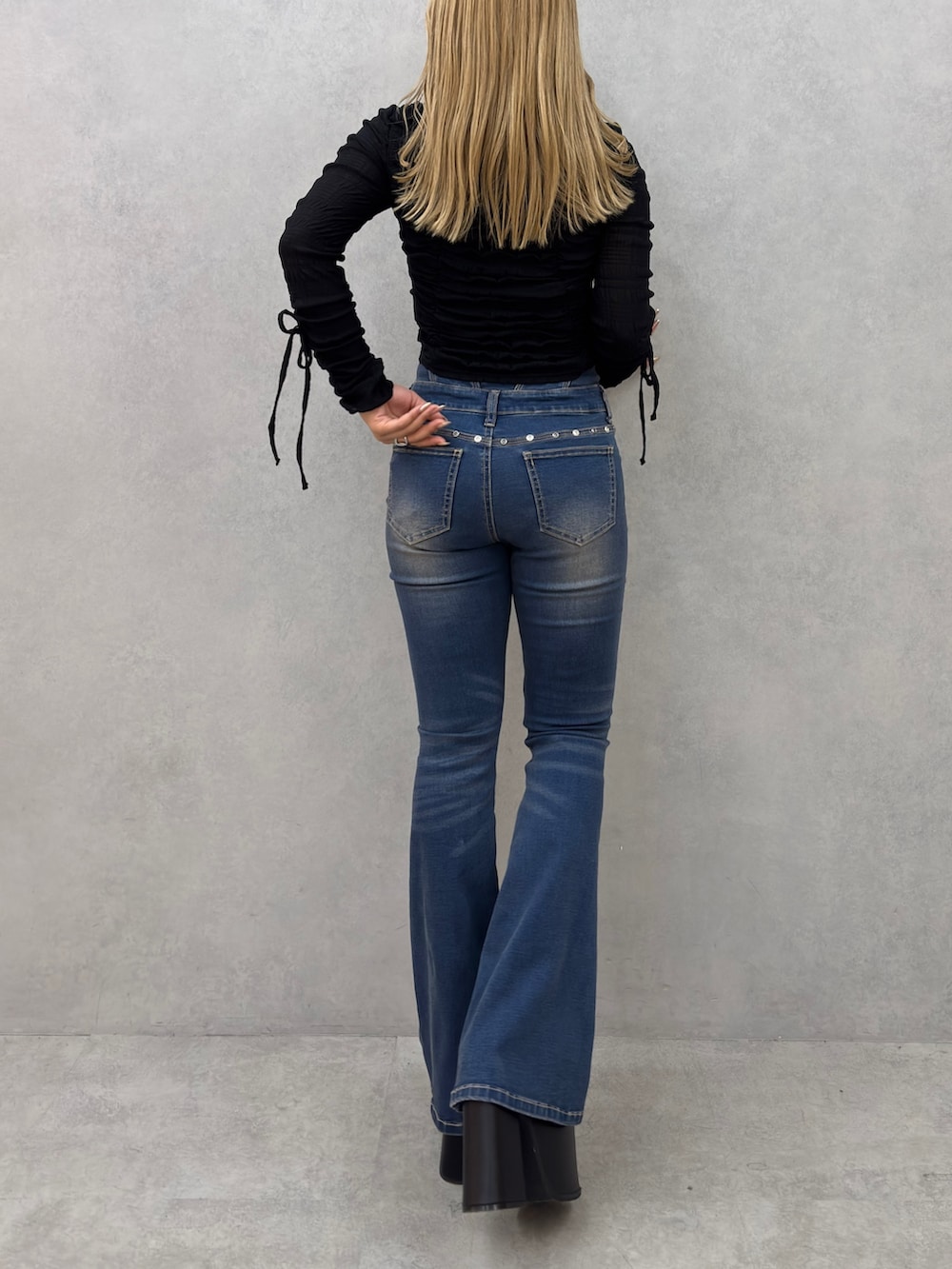 ブラック系のTシャツ/カットソー、ブルー系のデニムパンツ、ブラック系のサンダルを着用したレディースの冬コーディネートの3枚目の写真